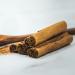 A close-up photograph of ground cinnamon and cinnamon bark