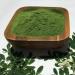 Moringa powder in a wooden bowl with fresh moringa leaves Moringa powder in a wooden bowl with fresh moringa leaves