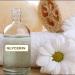 A bottle of Glycerine: Vegetable, Organic beside a white daisy and loofah sponge