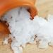 Magnesium chloride flakes pouring out of a terra cotta jar