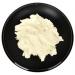 Arnica butter in a black bowl.