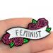 Enamel Pin with roses says Feminist held between fingers