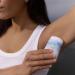 Applying a stick deodorant to an armpit