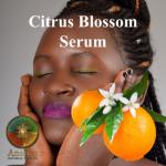 A woman caressing her face with orange blossoms and a tangerine in the 