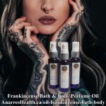 Tattooed woman with bottles of Perfume Oil: Frankincense Bath & Body