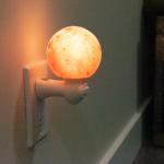 Himalayan Salt Lamp Salt Sphere Nightlight plugged into the wall.