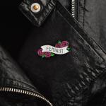 Enamel Pin with roses says Feminist on a leather jacket